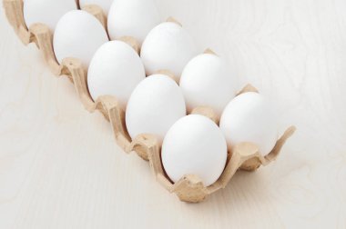 Masadaki kareli pakette beyaz tavuk yumurtası.