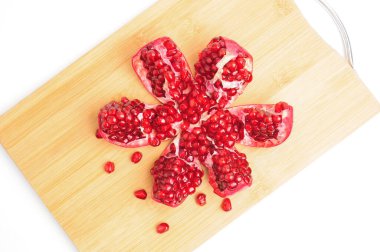 İzole edilmiş beyaz grupta dilimlenmiş nar kamaları.