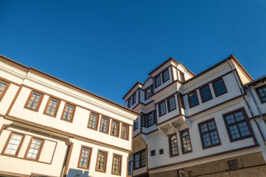 Ohri 'de deniz kıyısındaki bir tatil beldesinde tarihi evler. Arkaplanda mavi bir gökyüzü ile aşağıdan görüntüle.