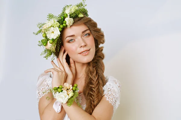 Bela jovem mulher em uma coroa de flores — Fotografia de Stock