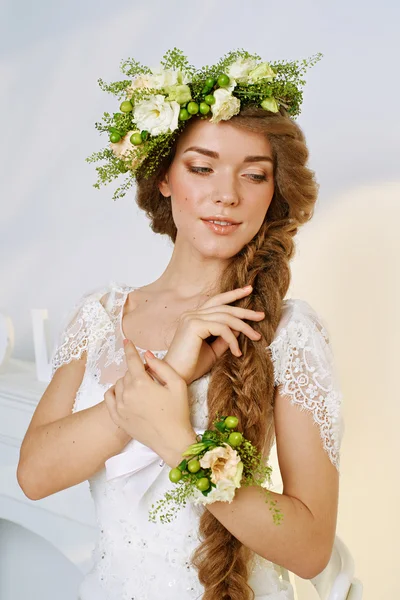 Mooie jonge vrouw in een bloem krans — Stockfoto