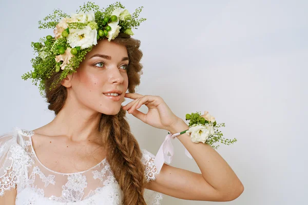 Bela jovem mulher em uma coroa de flores — Fotografia de Stock