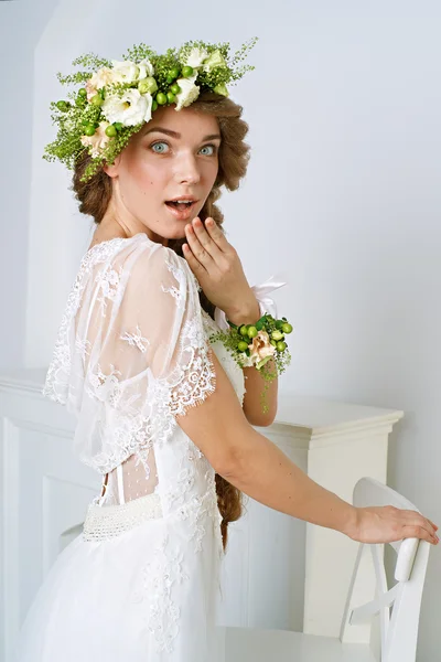 Schöne junge Frau in einem Blumenkranz — Stockfoto