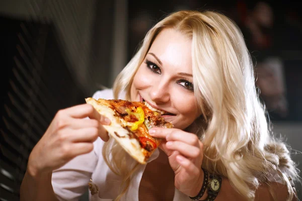 Attraktiv blond tjej äter pizza Royaltyfria Stockbilder