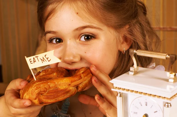 Милая маленькая девочка ест круассан — стоковое фото