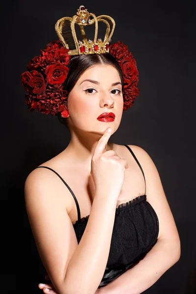 Retrato de morena com rosas vermelhas no cabelo e uma coroa — Fotografia de Stock