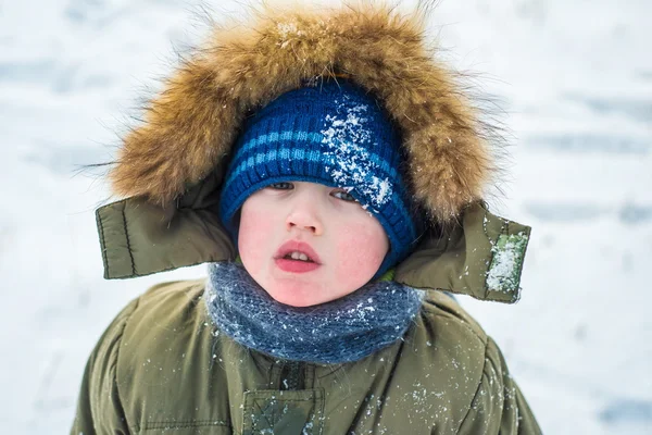 Porträtt av en liten pojke tittar på kameran utomhus på backg — Stockfoto