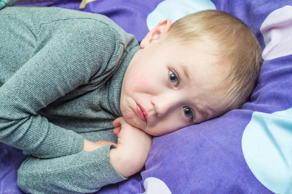 Pojke grepp patienten ligger i sängen med en termometer — Stockfoto