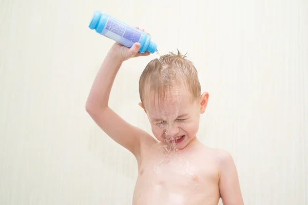 Niño pequeño vierte agua en su cabeza con una botella — Foto de Stock