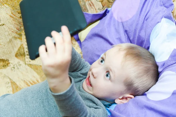 Adolescent garçon couché sur le lit avec une tablette PC — Photo