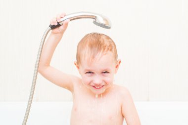 cute 4 year-old boy bathes in a shower clipart