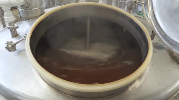 Pivo se vaří a fermentuje ve velkých hliníkových nádržích. Pěna na povrchu. Detailní záběr.
