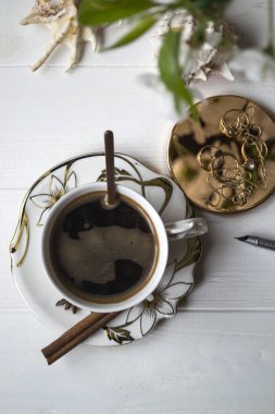 Bir fincan kahve ve çiçek dalları. Bahar sabahı.