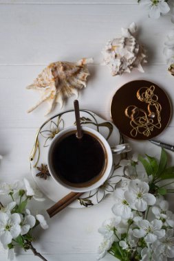 Bir fincan kahve ve çiçek dalları. Bahar sabahı.