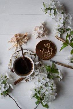 Bir fincan kahve ve çiçek dalları. Bahar sabahı.