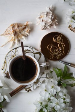 Bir fincan kahve ve çiçek dalları. Bahar sabahı.
