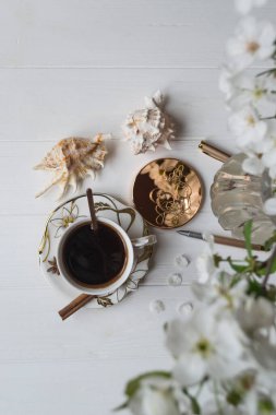 Bir fincan kahve ve çiçek dalları. Bahar sabahı.