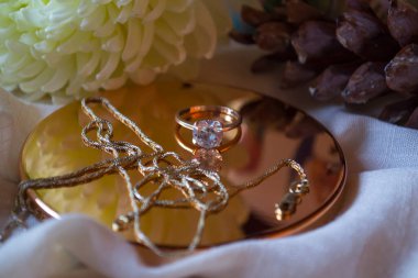 Altın zincir ve yüzük, çiçeğin yanındaki elmasla, yaklaş.