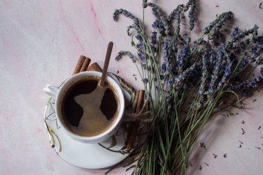 Tarçın ve lavanta çiçekli bir fincan kahve..