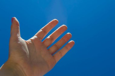 Mavi gökyüzü arkaplanına karşı kadın kolu.