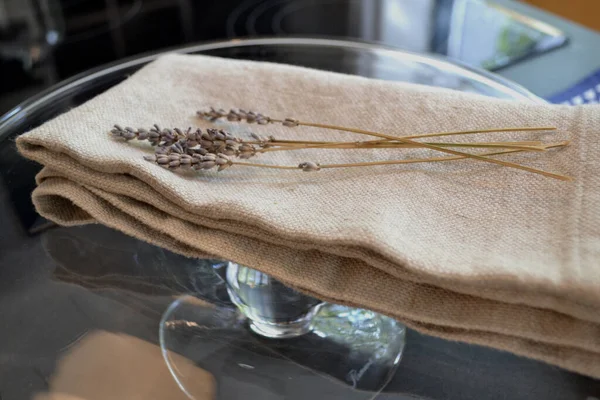 The lavender on a kitchen textile in a glass dish.