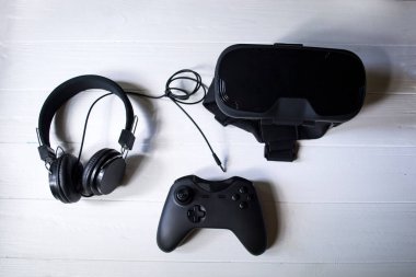 Beyaz arka planda sanal gerçeklik gözlükleri, joystick ve kulaklıklar..
