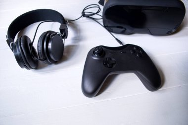 Beyaz arka planda sanal gerçeklik gözlükleri, joystick ve kulaklıklar..