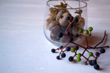 Masanın üstündeki camda meşe palamudu var, kapat. Doğal ev dekorasyonu.