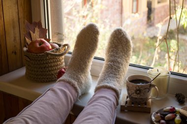 Evde bir fincan kahveyle rahatlayan bir kadın.