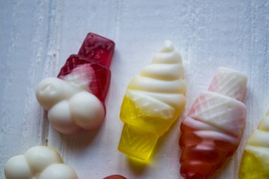 Beyaz arkaplanda parlak şekerler, yakın plan.