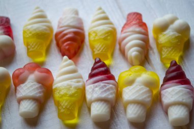 Beyaz arkaplanda parlak şekerler, yakın plan.