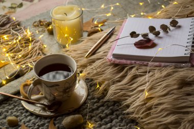 Masada bir fincan çay ve dekor var. Hygge tarzı. Kış hala hayat.