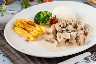 Kızarmış tavuk, pilav ve kızarmış patates.