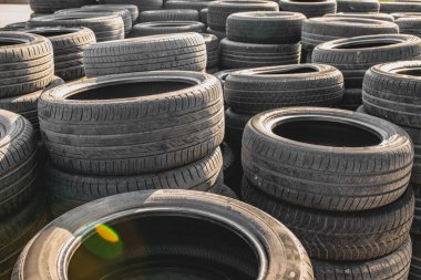 Eski ve yıpranmış araba lastikleri üst üste yığılmış..