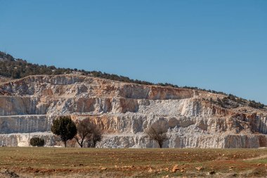 Taş ocağında çakıl ve kireç taşı var. Dik duvarlarda patlama izleri var.