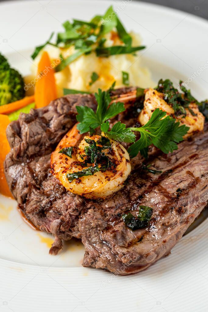 Delicious juicy grilled steak and shrimp with grilled broccoli and cauliflower.  Surf and Turf style. 