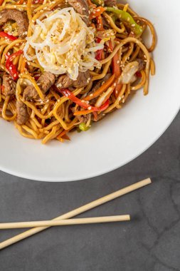 Makarna çorbası ve arka planda biftek.