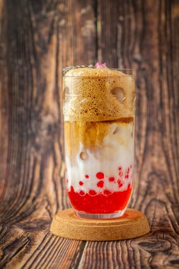 Ahşap zemin üzerinde cam fincanda meyveli baloncuk çayı