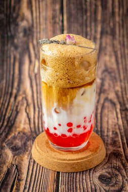 Ahşap zemin üzerinde cam fincanda meyveli baloncuk çayı