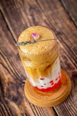 Ahşap zemin üzerinde cam fincanda meyveli baloncuk çayı