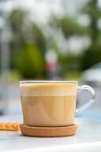 Cafe latte and heart waffles on marble table in the garden of the cafe