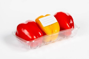 İzole edilmiş beyaz arka planda beyaz etiketli kırmızı ve sarı biber paketi