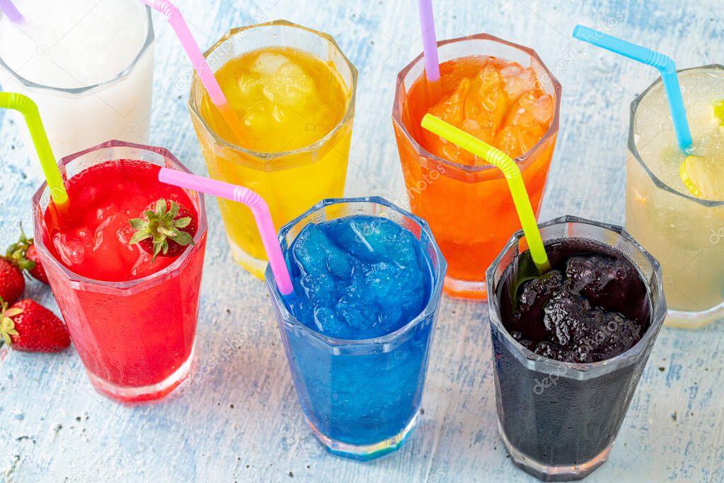 Refreshing frozens in various fruits and colors on a blue background.