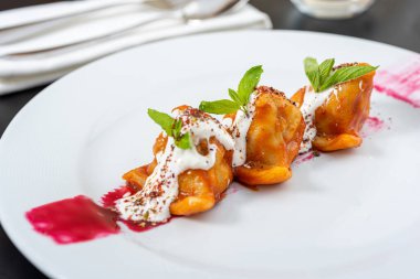 Geleneksel Rus yemeği pelmeni, domates soslu Rus köftesi ve yoğurt.