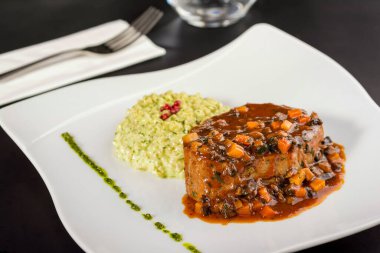 Porselen tabakta sığır filetosu ve fesleğen pilavı.