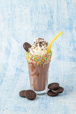 Mavi arka planda krema ve çikolatalı milkshake.