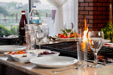 Masada ızgara yapılmış farklı et türleri, özel Türk aperatifleri ve Türk rakısıyla servis ediliyor..