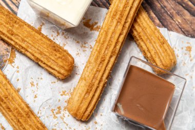 Tahta masada çikolata soslu sıcak churro..