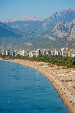 Antalya 'da güneş doğarken Konyaalti plajı ve çam kaplı sahil manzarası