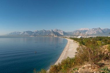 Antalya 'da güneş doğarken Konyaalti plajı ve çam kaplı sahil manzarası